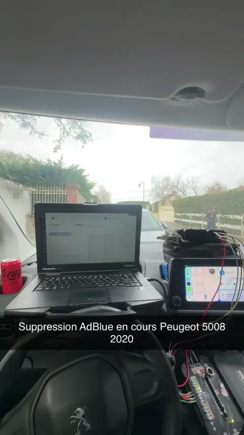 Ordinateur de diagnostic branché dans l'habitacle d'un Peugeot 5008 pendant l'intervention