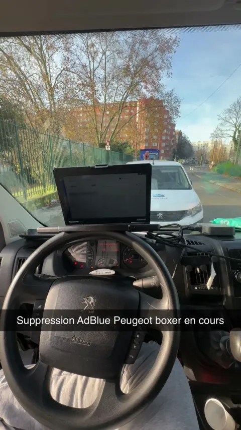 Ordinateur de diagnostic posé sur le tableau de bord d'un Peugeot Boxer