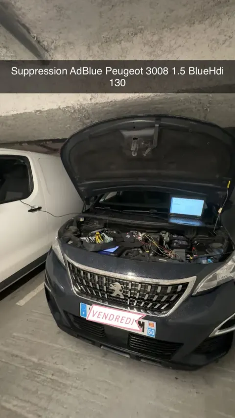 Peugeot 3008 capot ouvert dans un parking souterrain, ordinateur de diagnostic branché au moteur